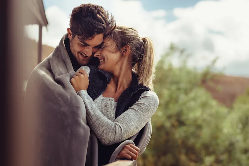 Couple embracing each other and smiling.
