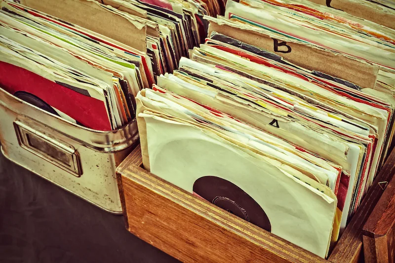 Retro styled image of boxes with vinyl turntable records on a flee market
