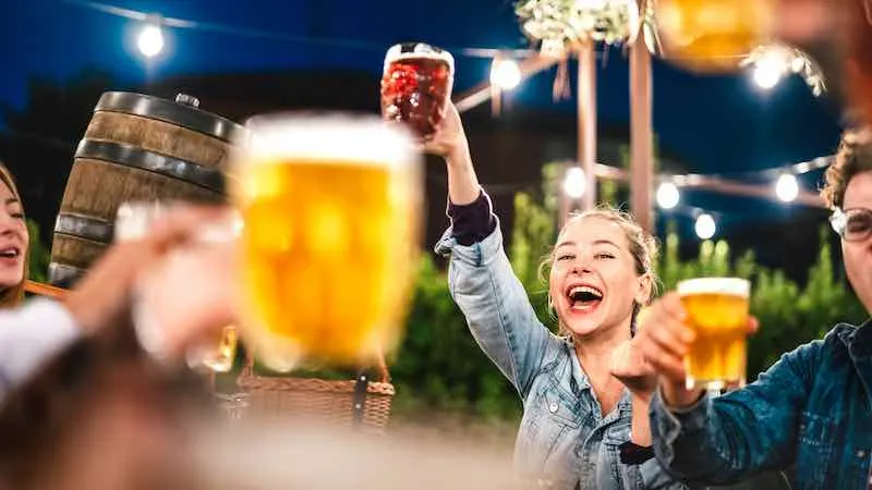 toasting beer at brewery bar restaurant patio with friends