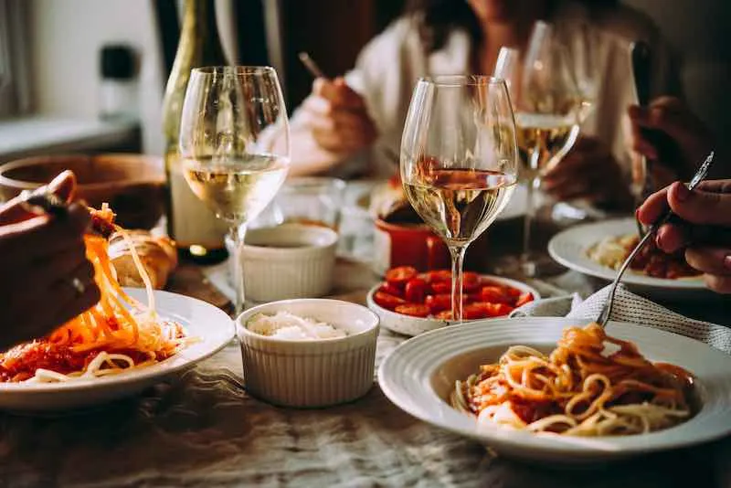 Friends having a pasta dinner at home of at a restaurant