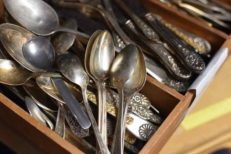 Wooden box of old, tarnished antique silverware