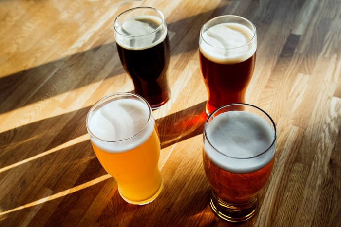 Overhead view of four glasses on craft beer on table.