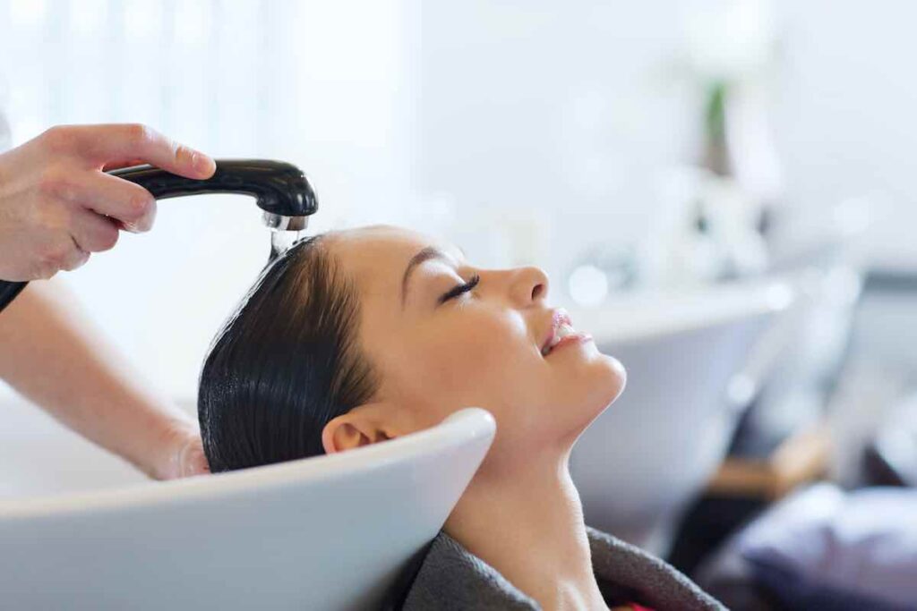 hairdresser washing head at hair salon