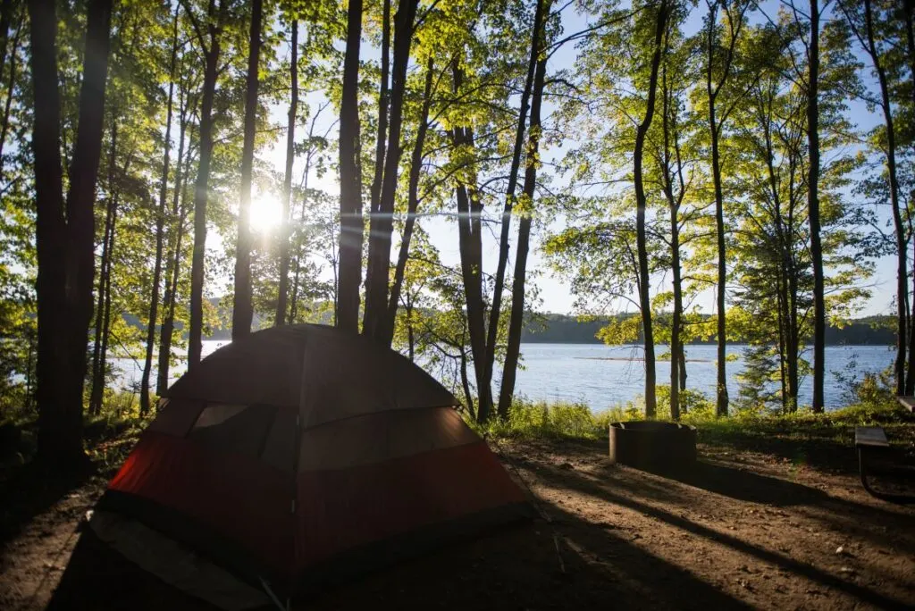 A tent in a forest by a lake. Maybe one of the best campgrounds in Michigan.