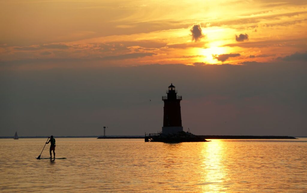 Sunset at Cape Henlopen State Park behind a lighthouse.