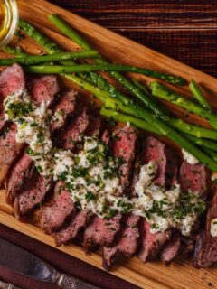 Steak and asparagus on a cutting board. Perhaps steak from the best steakhouse in Michigan.