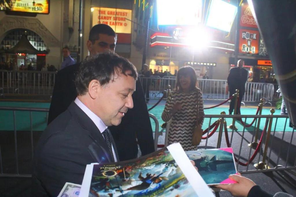 Director Sam Raimi, one of the many famous people from Michigan, attends premiere of "Oz: The Great and Powerful" at the El Capitan Theatre and gives autographs. 
