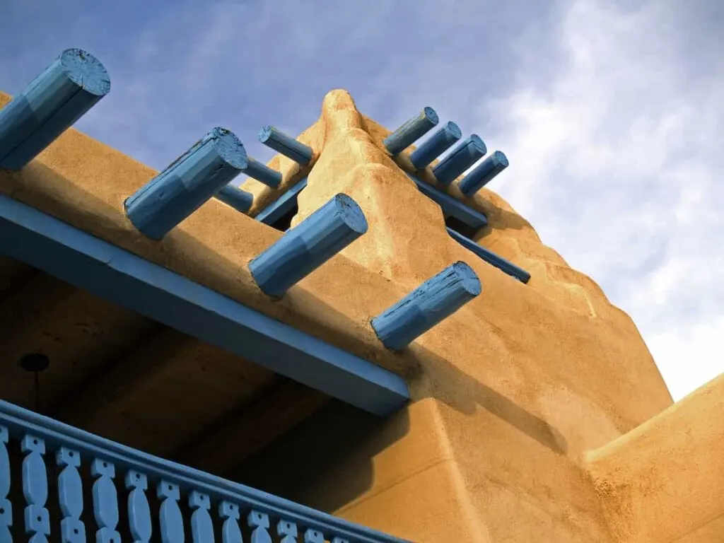 View of blue wooden details on a pueblo-style building in Taos, NM.