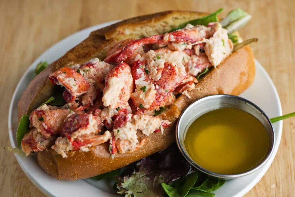 A lobster roll sandwich and a small bowl of butter for dipping.